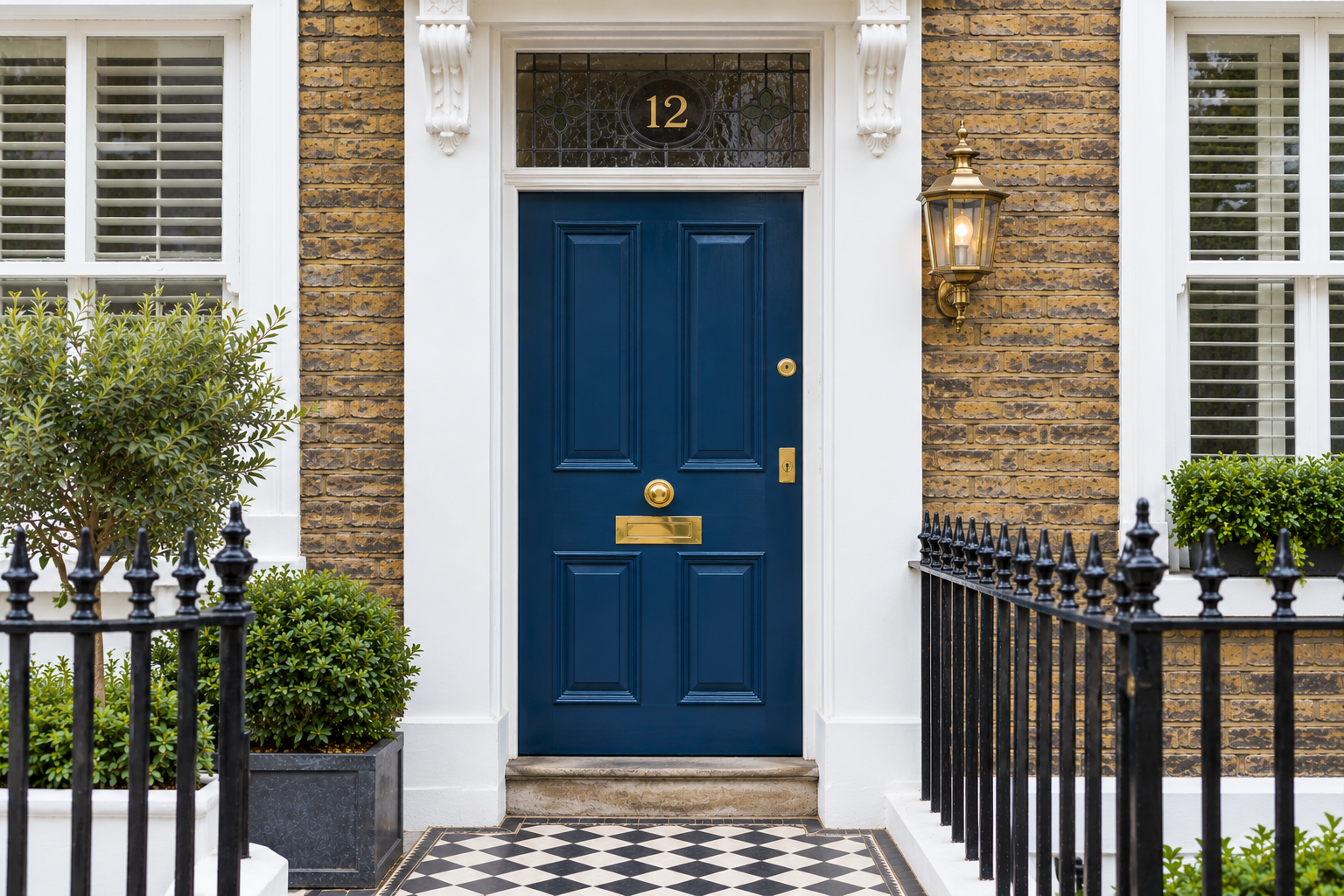 Classic blue-painted timber Victorian entrance door with polished brass ironmongery on a British townhome